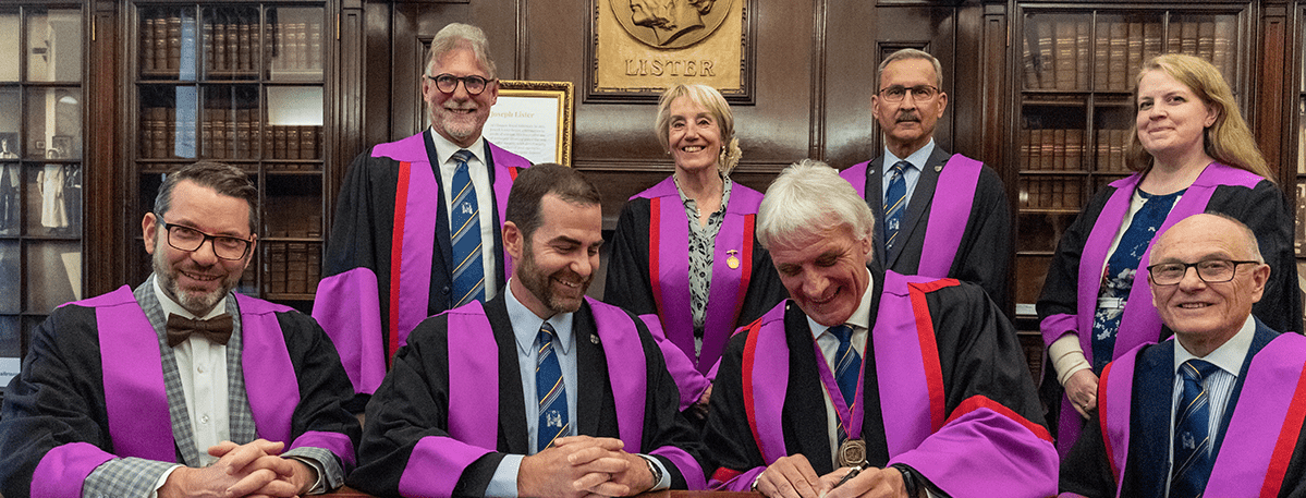 A group of podiatry Members signing a document